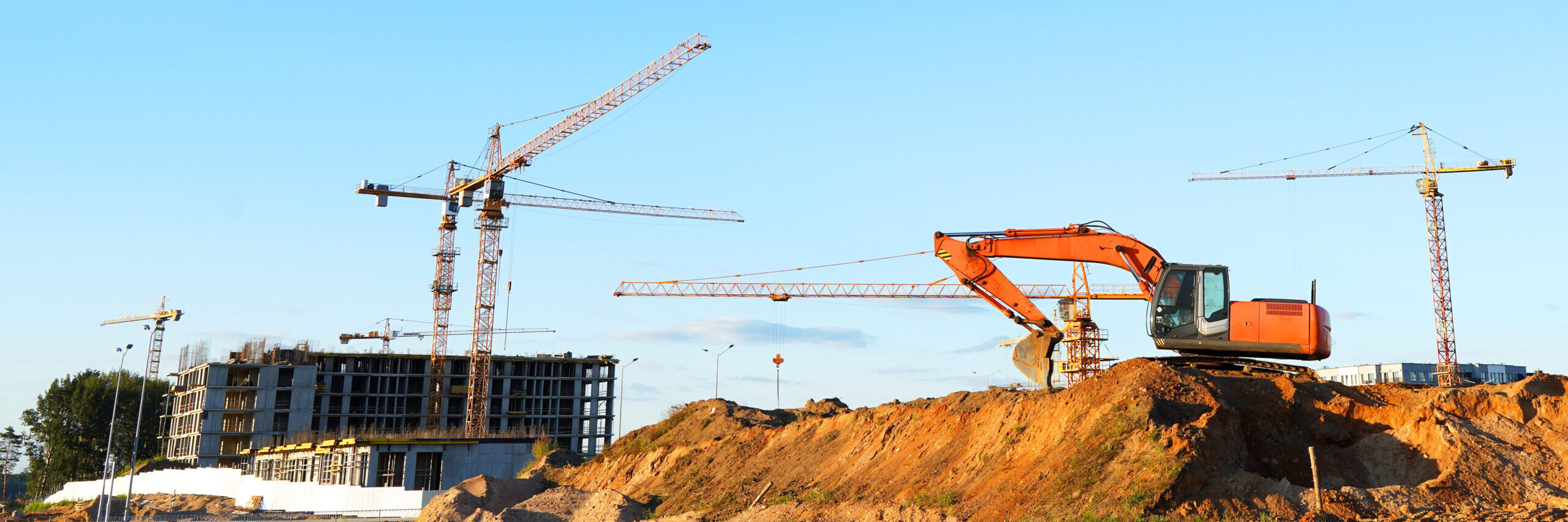 Construction site with an excavator and tower cranes